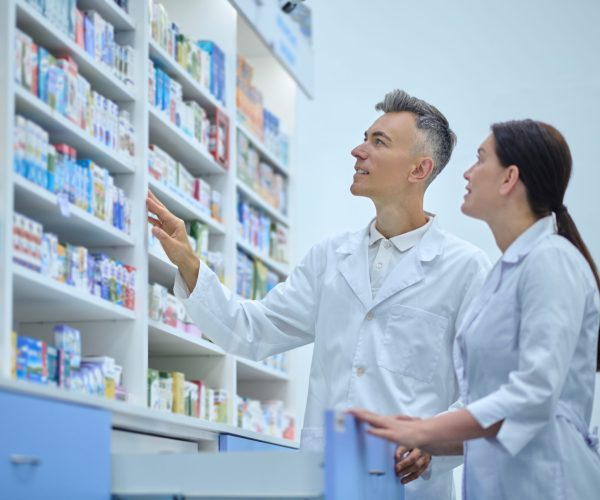 Two druggists in lab coats in the process of inventory in a drugstore